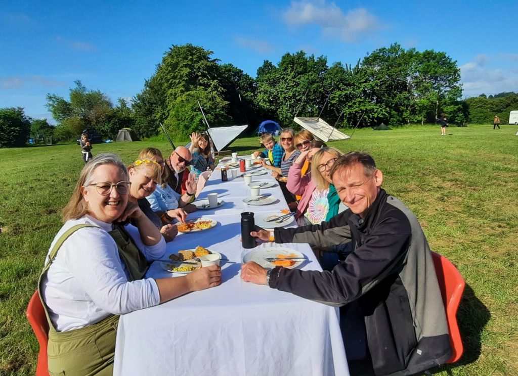 Everyone together at the long dinner table outdoors
