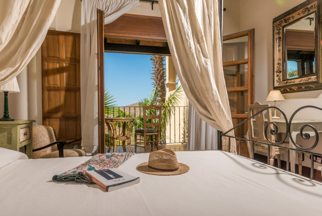 Bedroom with four-poster bed and balcony